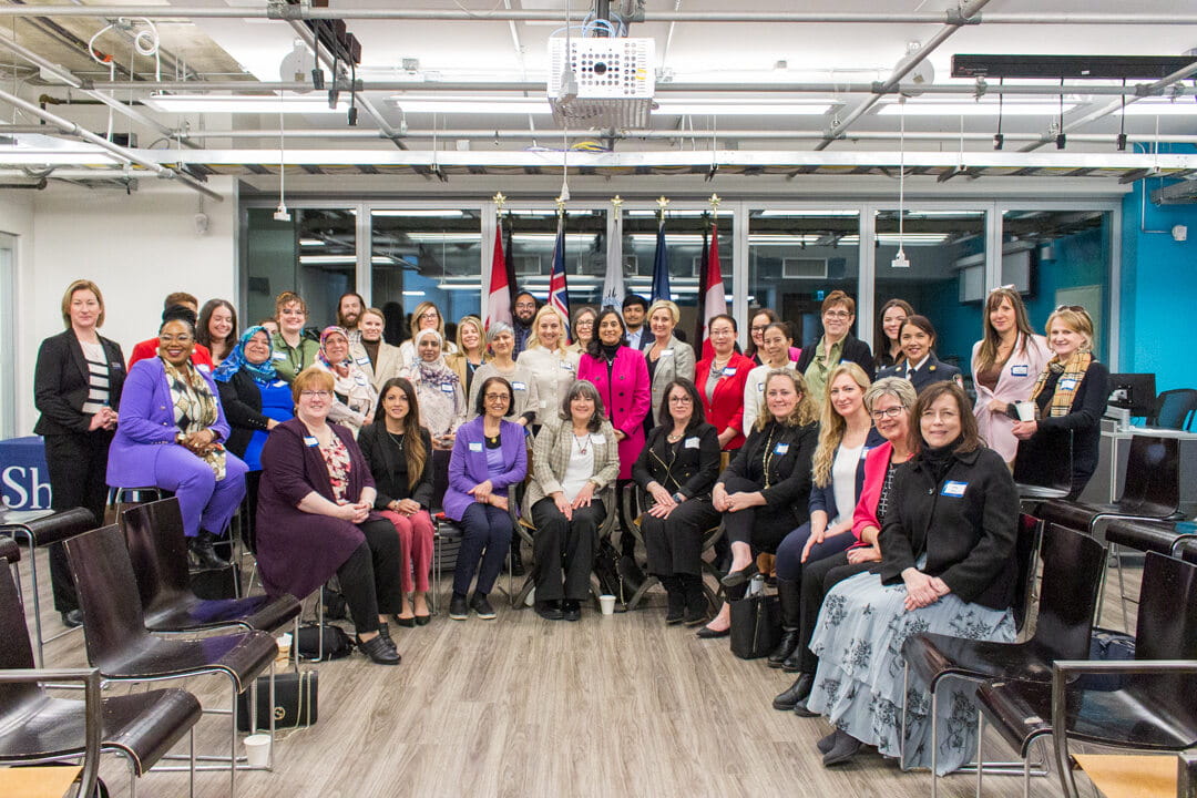 Canadian Minister of Defence Anita Anand stands in the middle of invited guests to Sheridan's International Women's Day event